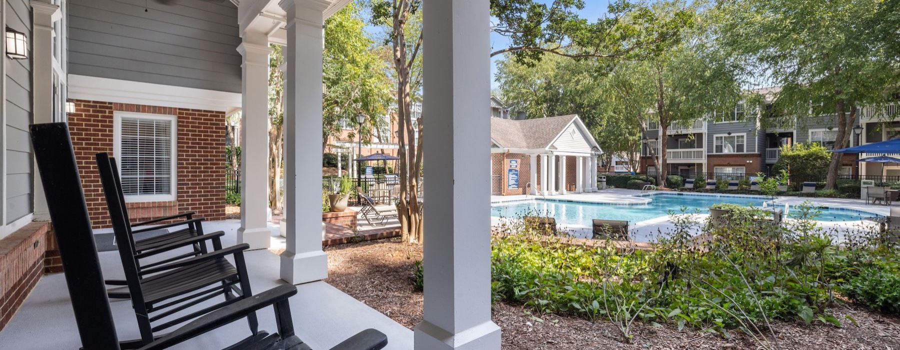 rocking chairs on a porch with a pool
