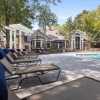 a pool with chairs and tables by it